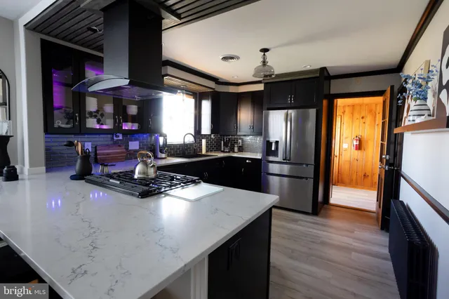a kitchen with stainless steel appliances granite countertop a sink a stove and a refrigerator