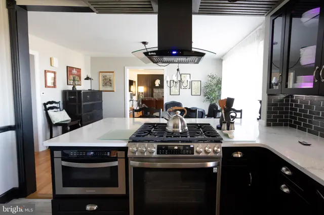 a kitchen with stainless steel appliances kitchen island granite countertop a stove a sink and a microwave