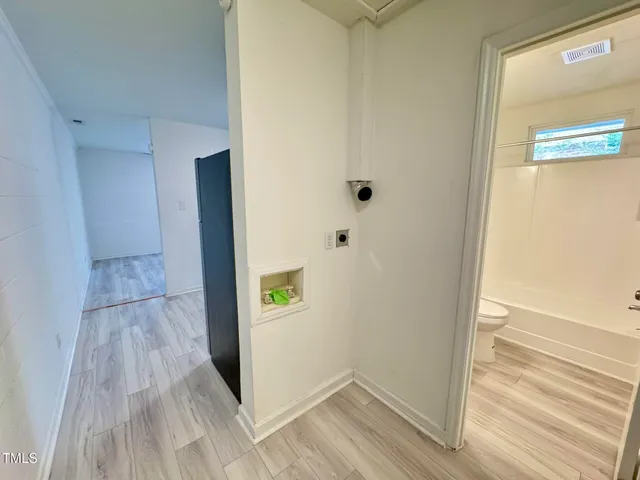 a view of a hallway with wooden floor and closet