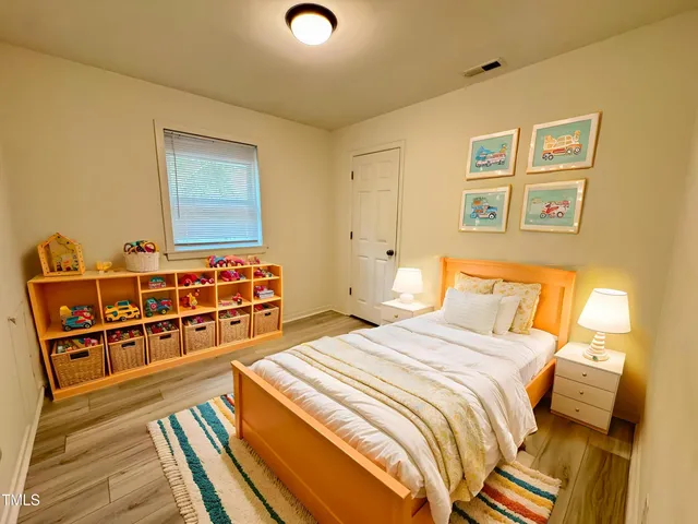 a bedroom with bed and wooden floor