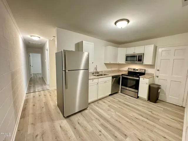 a kitchen with granite countertop a refrigerator and a stove top oven