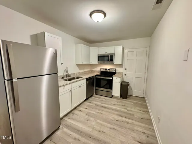 a kitchen with stainless steel appliances granite countertop a refrigerator stove a sink dishwasher and a refrigerator