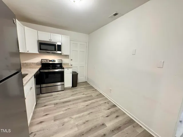 a kitchen with stainless steel appliances a stove top oven a sink and dishwasher