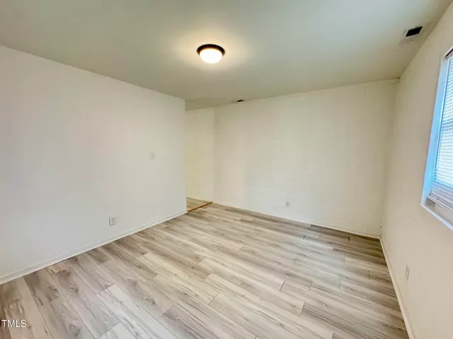 a view of room with wooden floor and natural light