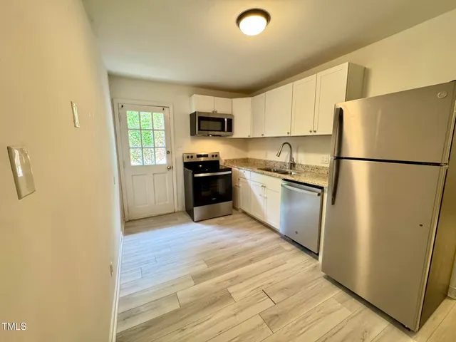 a kitchen with stainless steel appliances a refrigerator sink and microwave