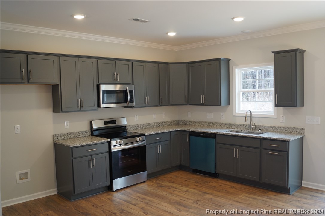 88 Knotts Berry Road Bunnlevel, NC 28323 - Photo 6 of 33 a kitchen with a sink stove top oven and cabinets