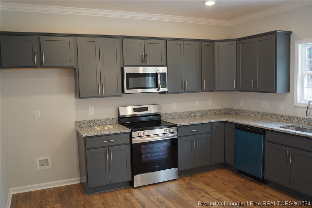 88 Knotts Berry Road Bunnlevel, NC 28323 - Photo 7 of 33 a kitchen with granite countertop wooden cabinets and stainless steel appliances