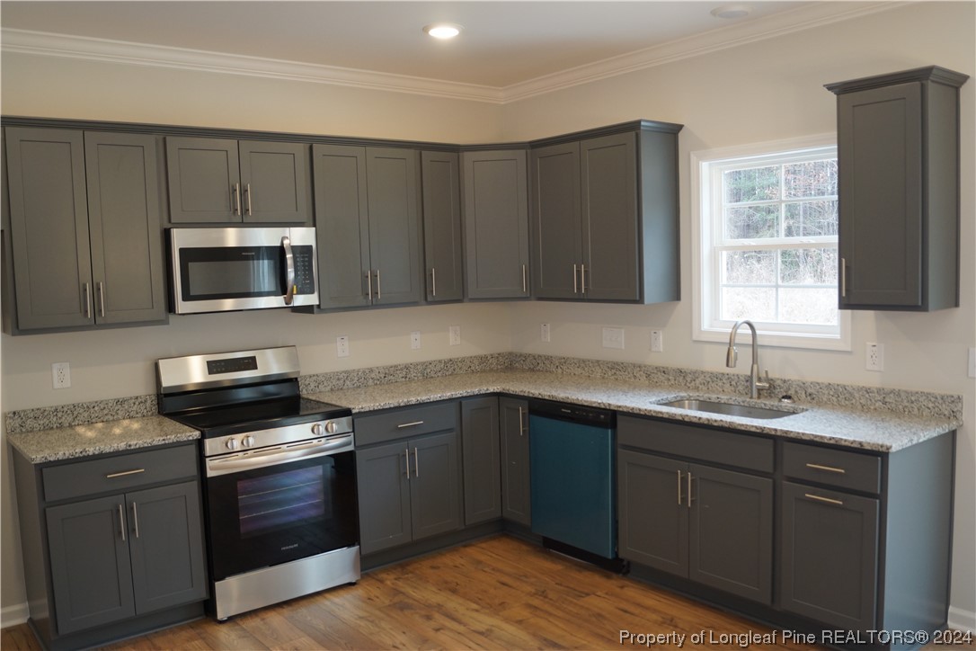 88 Knotts Berry Road Bunnlevel, NC 28323 - Photo 8 of 33 a kitchen with sink a microwave a stove and cabinets