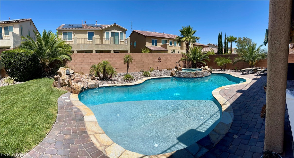 9724 University Ridge Avenue Las Vegas, NV 89149 - Photo 27 of 61 An inviting backyard oasis offers a freeform swimming pool with rock features and an integrated spa.