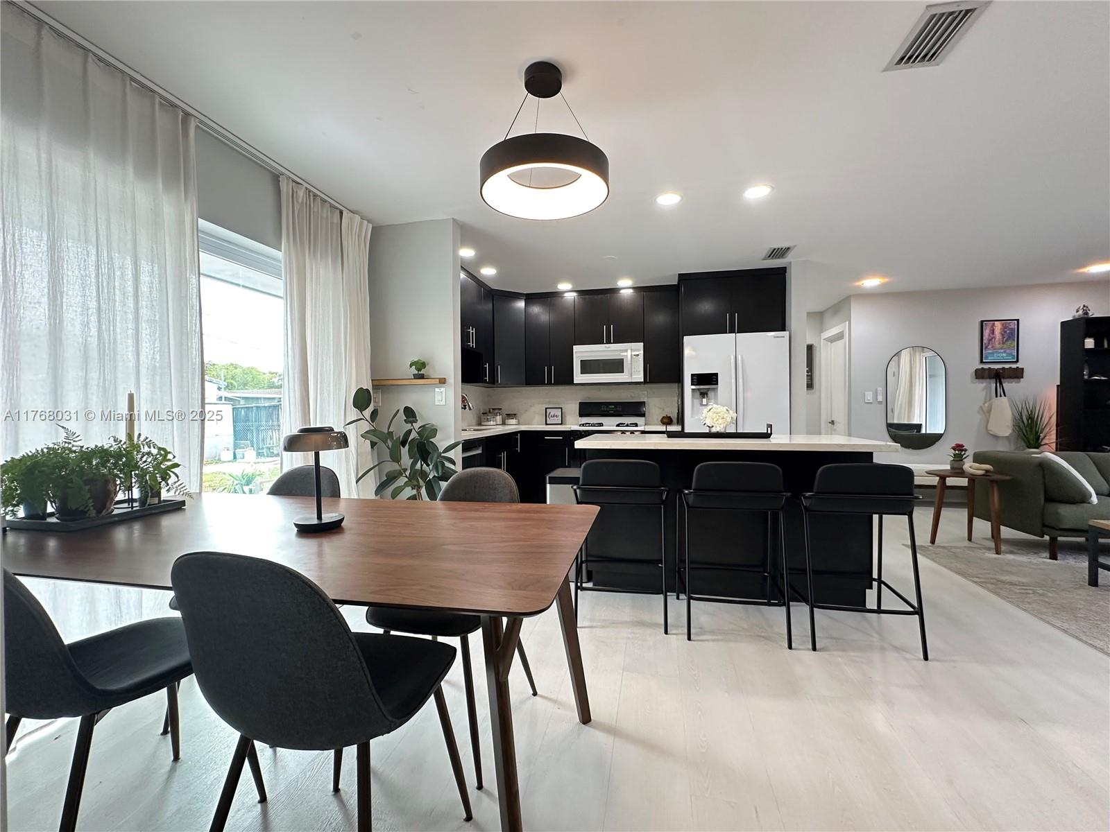 2001 North 31st Road Hollywood, FL 33021 - Photo 1 of 75 a kitchen with a dining table chairs and a refrigerator