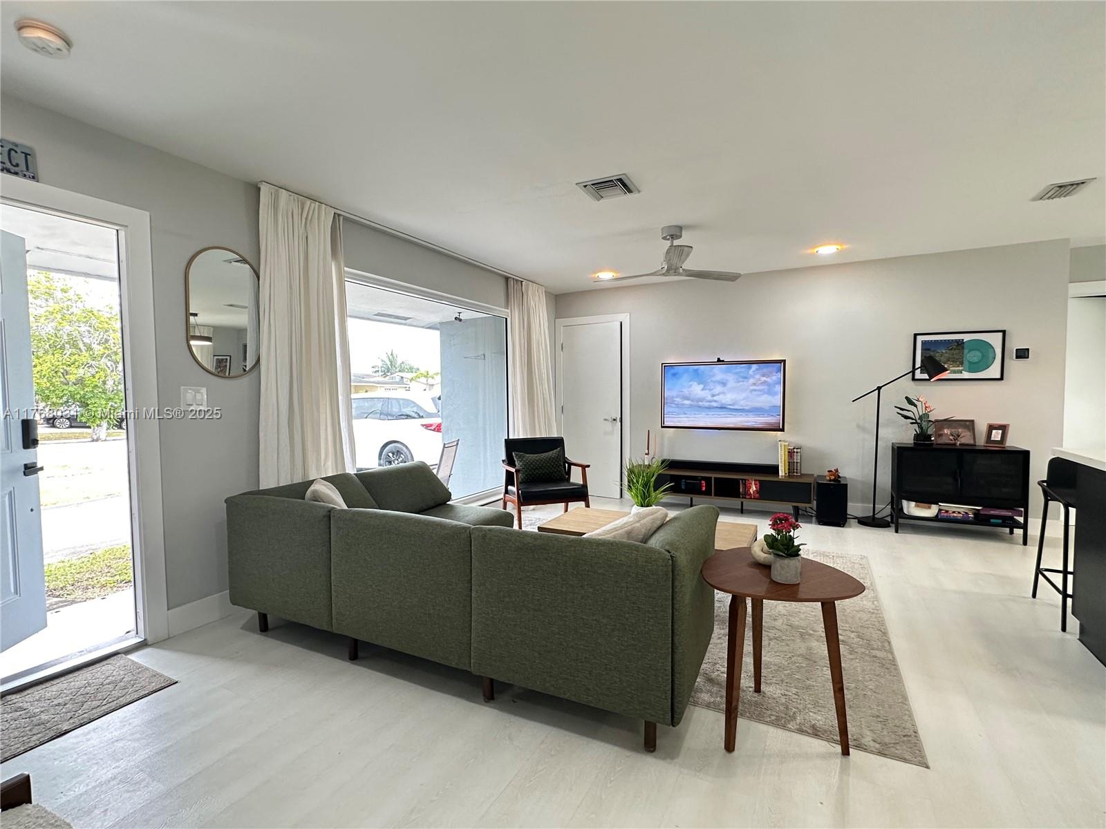 2001 North 31st Road Hollywood, FL 33021 - Photo 28 of 75 a living room with furniture a large window and a flat screen tv