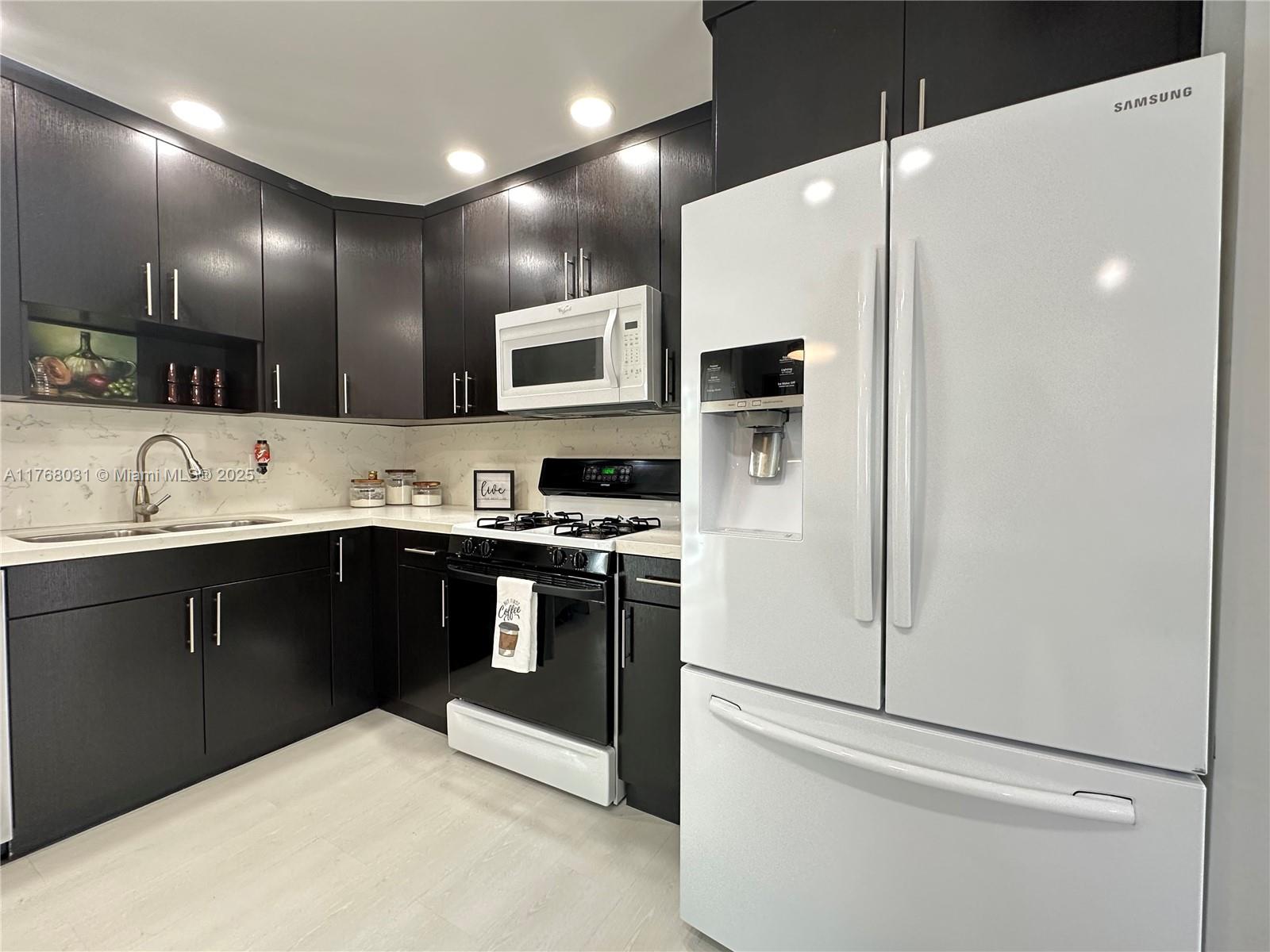 2001 North 31st Road Hollywood, FL 33021 - Photo 38 of 75 a kitchen with stainless steel appliances kitchen island granite countertop a refrigerator sink and stove