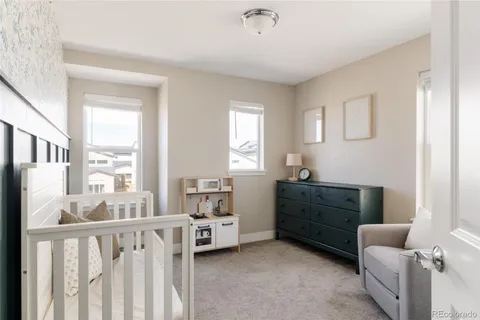 a room with furniture a baby crib and a dresser
