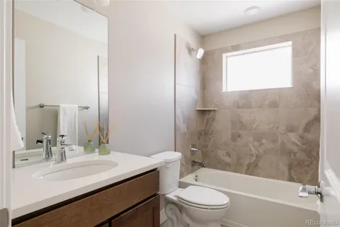 a bathroom with a sink a toilet a mirror and shower