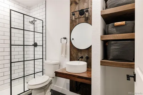 a bathroom with a sink toilet a mirror and shower