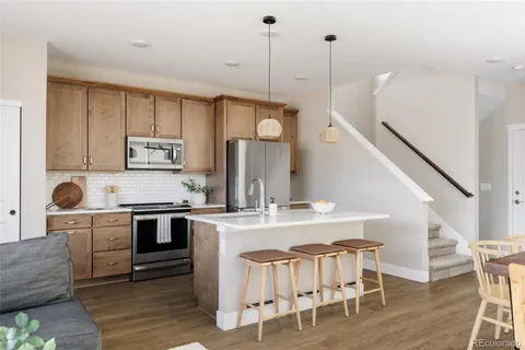 a kitchen with kitchen island a stove a table and chairs