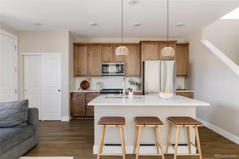 a view of kitchen island with stainless steel appliances granite countertop furniture and a wooden floor