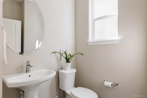 a bathroom with a sink a toilet and mirror