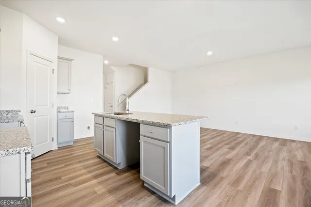 a kitchen with a sink stove and wooden floor