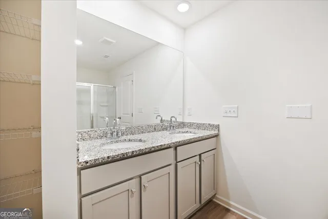 a bathroom with a granite countertop sink and a mirror