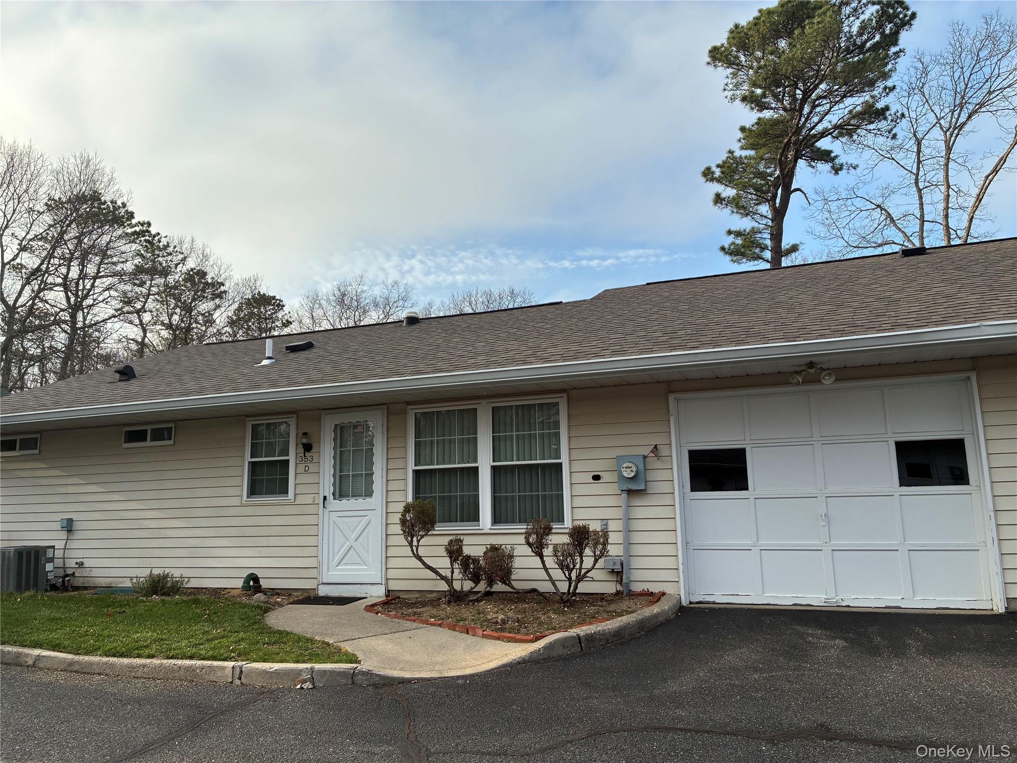 353 Woodbridge Drive Ridge, NY 11961 - Photo 2 of 11 a front view of a house with a garage
