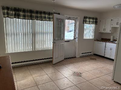 353 Woodbridge Drive Ridge, NY 11961 - Photo 4 of 11 a room with a black white checkered floor next to a window