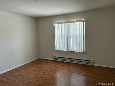 353 Woodbridge Drive Ridge, NY 11961 - Photo 6 of 11 an empty room with wooden floor and windows