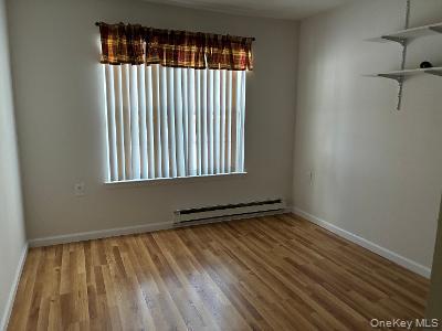 353 Woodbridge Drive Ridge, NY 11961 - Photo 8 of 11 a view of an empty room with wooden floor and a window