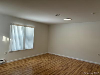 353 Woodbridge Drive Ridge, NY 11961 - Photo 10 of 11 an empty room with wooden floor and windows