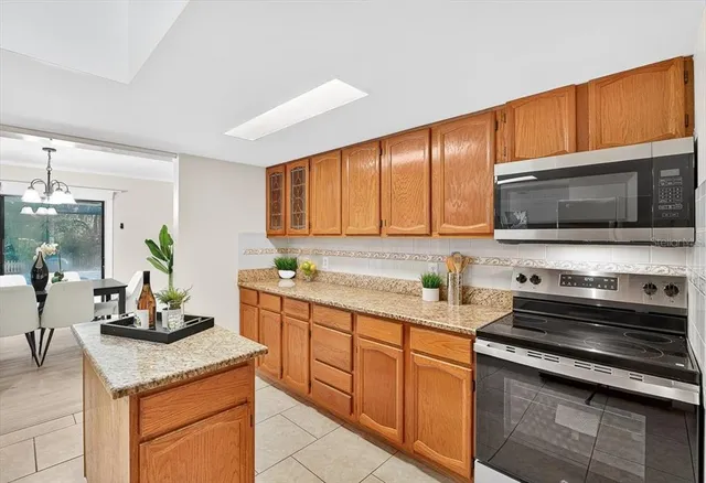 a kitchen with stainless steel appliances granite countertop a sink stove microwave and refrigerator