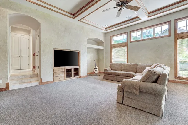 a living room with furniture a floor to ceiling windows and a chandelier
