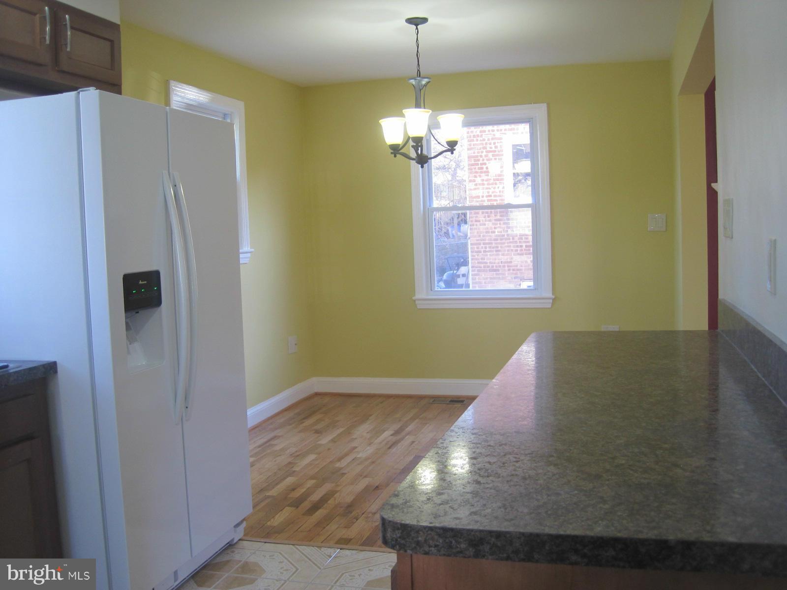 6517 Red Top Road Hyattsville, MD 20783 - Photo 11 of 23 a view of a kitchen with a refrigerator wooden floor and a kitchen