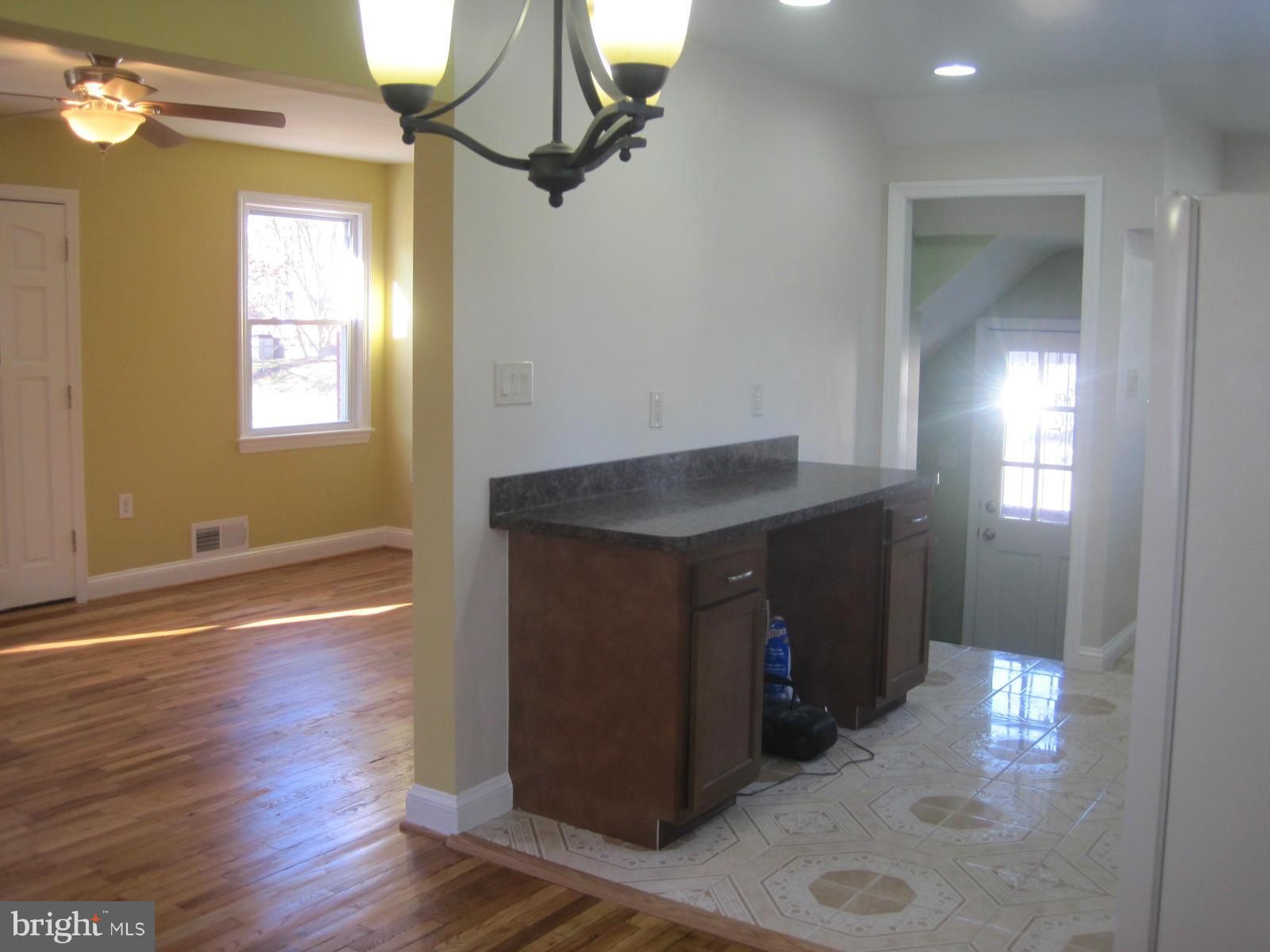 6517 Red Top Road Hyattsville, MD 20783 - Photo 13 of 23 a kitchen with kitchen island a sink wooden floor and a fireplace