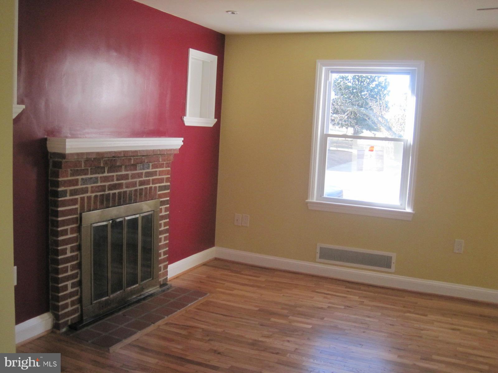 6517 Red Top Road Hyattsville, MD 20783 - Photo 8 of 23 a view of an empty room with wooden floor and a fireplace