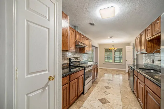 a kitchen with stainless steel appliances granite countertop a stove and a sink