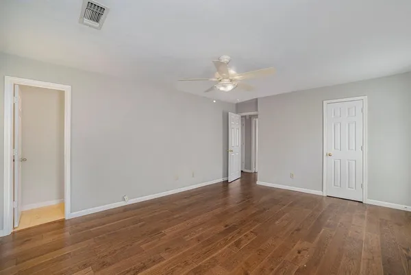 a view of an empty room with wooden floor
