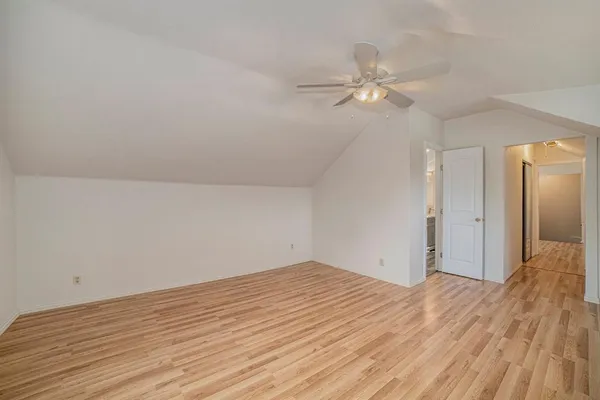 a view of a room with wooden floor and a ceiling fan