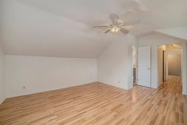 a view of a room with wooden floor and a ceiling fan
