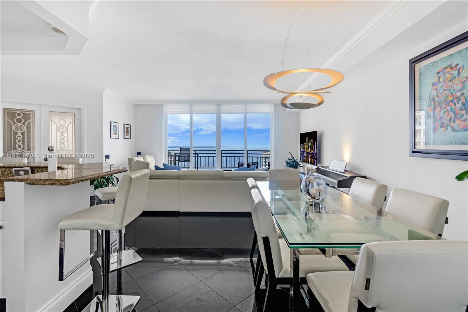 848 Brickell Key Drive, Unit 3803 Miami, FL 33131 - Photo 23 of 42 a kitchen with a table chairs sink and cabinets