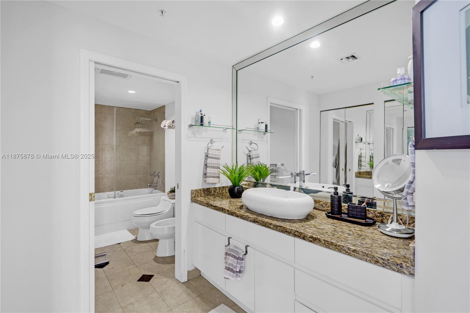 848 Brickell Key Drive, Unit 3803 Miami, FL 33131 - Photo 37 of 42 a bathroom with a granite countertop sink mirror and toilet