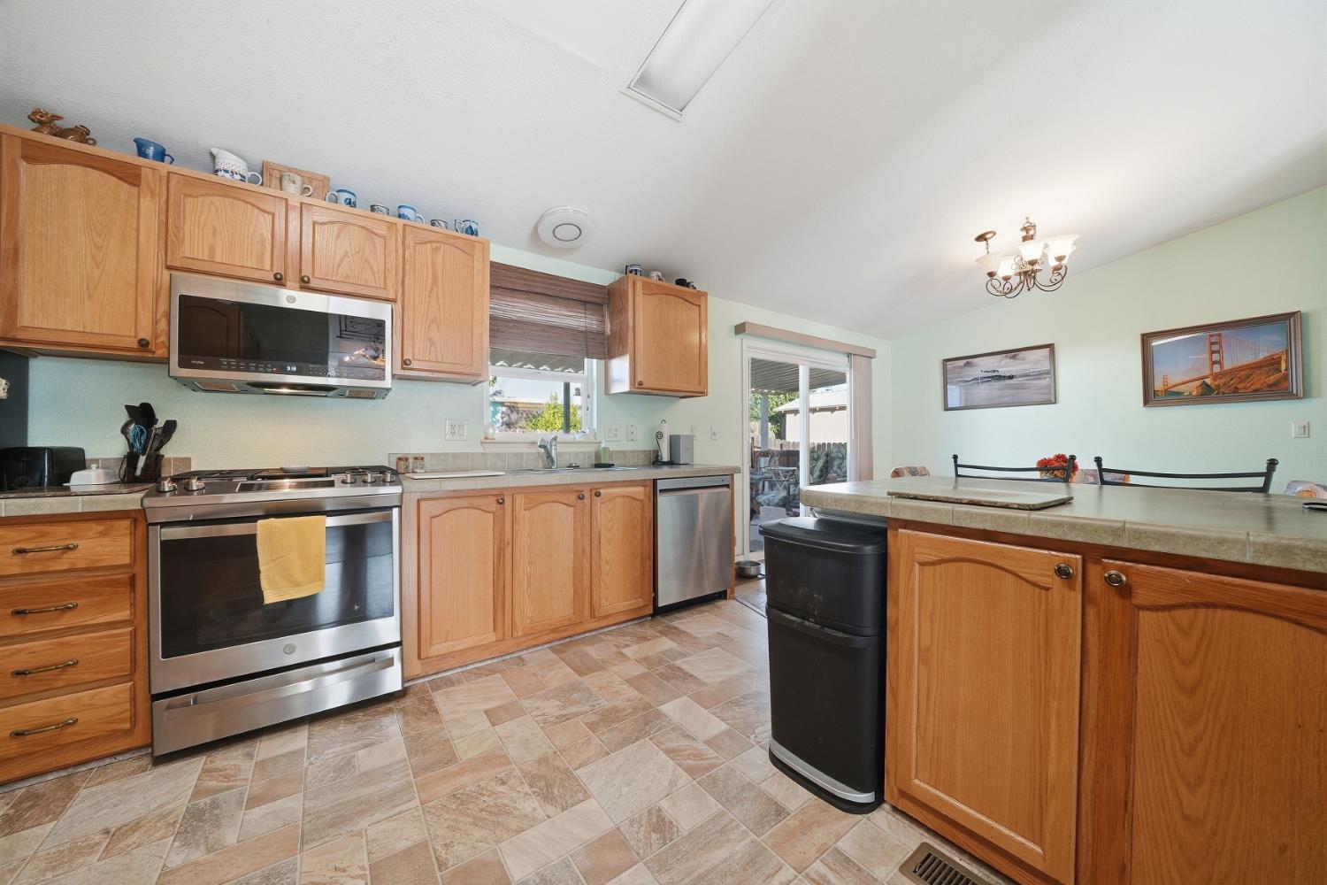 1400 West Marlette Street, Unit 33 Ione, CA 95640 - Photo 14 of 33 a kitchen with stainless steel appliances granite countertop a stove top oven a sink dishwasher and a microwave oven with large cabinets