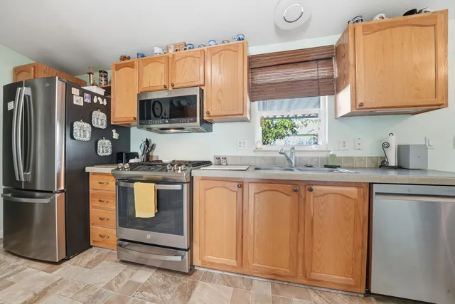 a kitchen with stainless steel appliances granite countertop a refrigerator and a sink