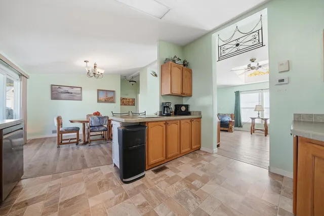 a kitchen with stainless steel appliances kitchen island granite countertop a stove a sink a dining table and chairs