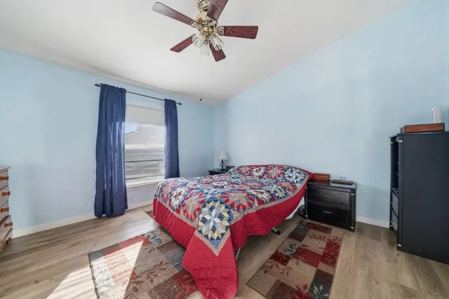 a bedroom with a bed and wooden floor