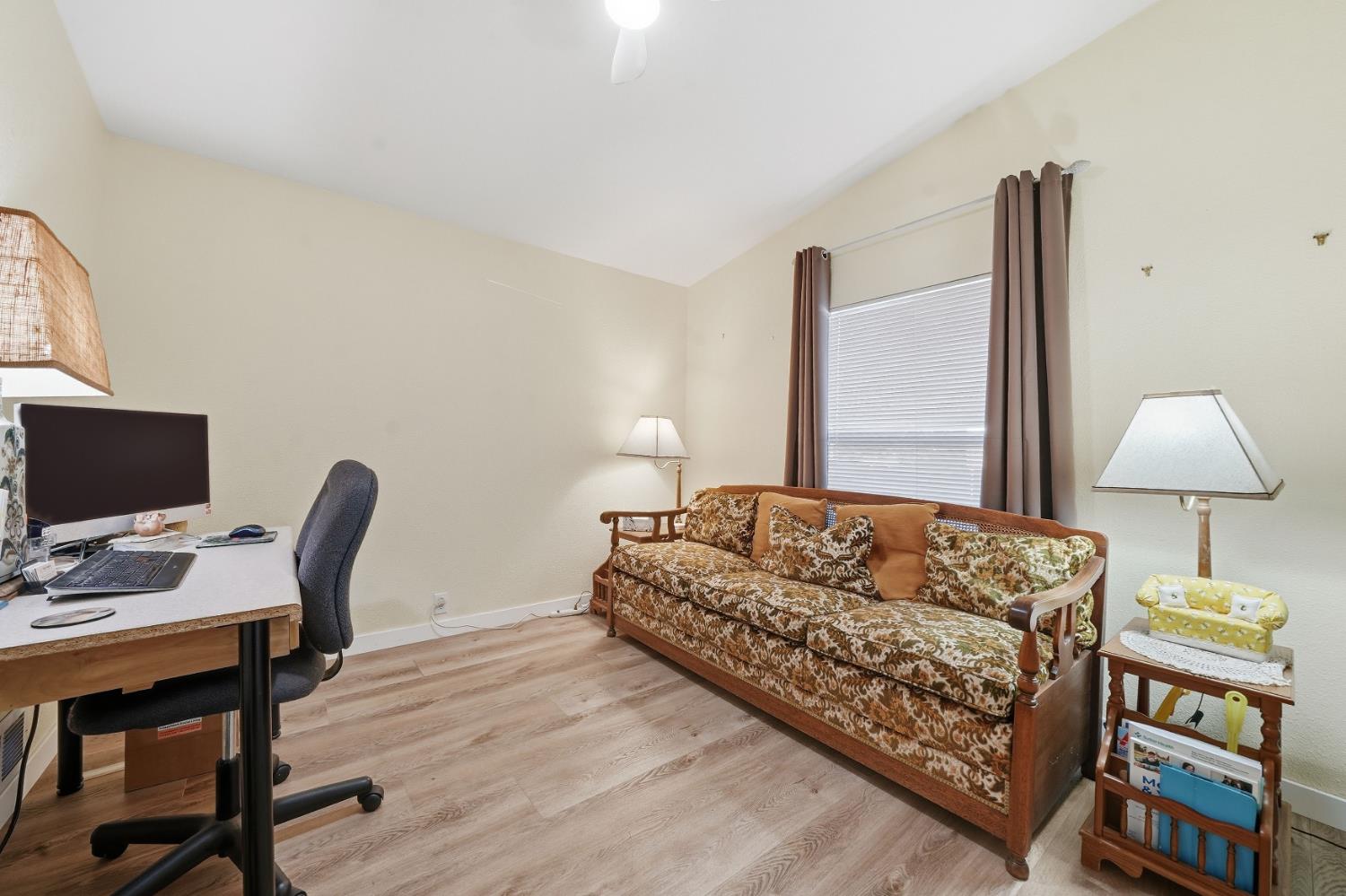 1400 West Marlette Street, Unit 33 Ione, CA 95640 - Photo 26 of 33 a bedroom with a bed a desk and chair with wooden floor