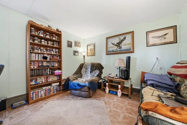 a living room with furniture a bookshelf and a piano
