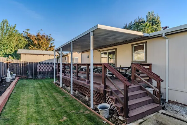 a view of a house with backyard and wooden fence