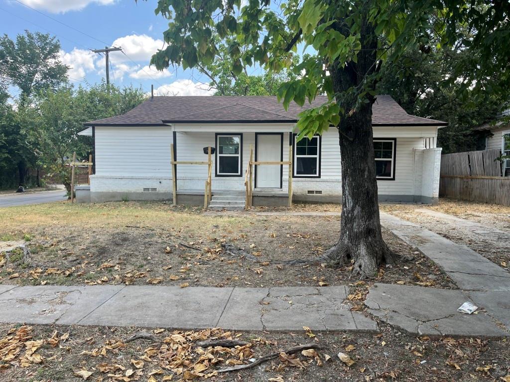 a front view of a house with a yard covered with trees