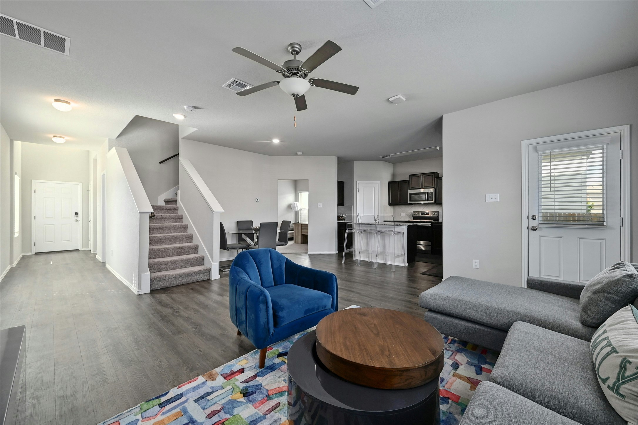 100 Comet Drive, Unit 1I Jarrell, TX 76537 - Photo 14 of 25 Living area with stairs, dark wood finished floors, and ceiling fan