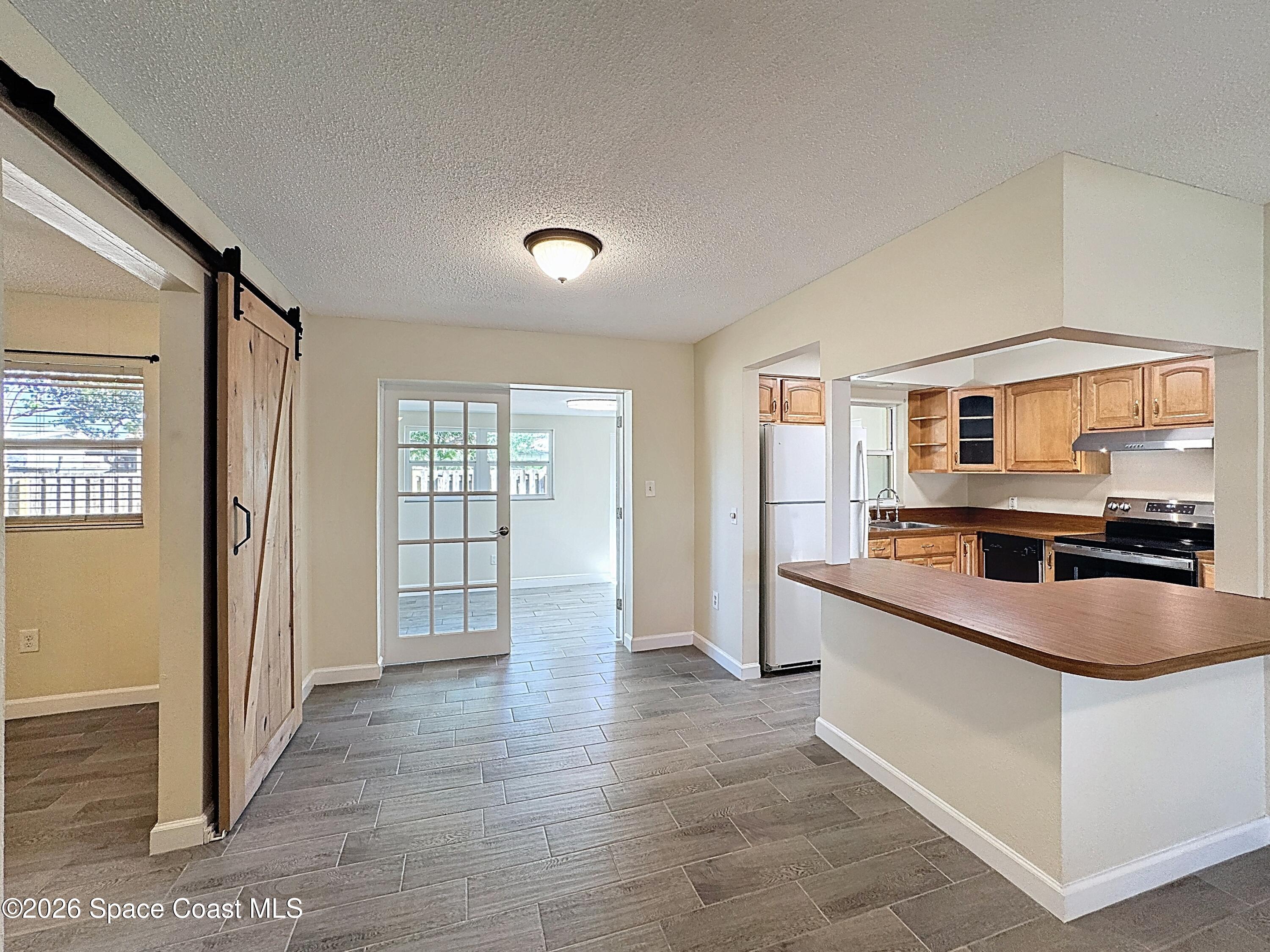 1315 Lester Court Merritt Island, FL 32952 - Photo 11 of 40 a large kitchen with stainless steel appliances granite countertop a large counter top and a wooden floors